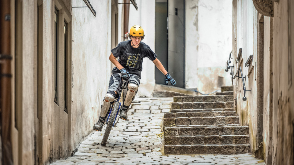 Einradfahrer fährt durch Gasse